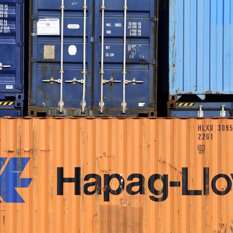 Gestapelte Container mit unterschiedlichen Firmenaufdrucken