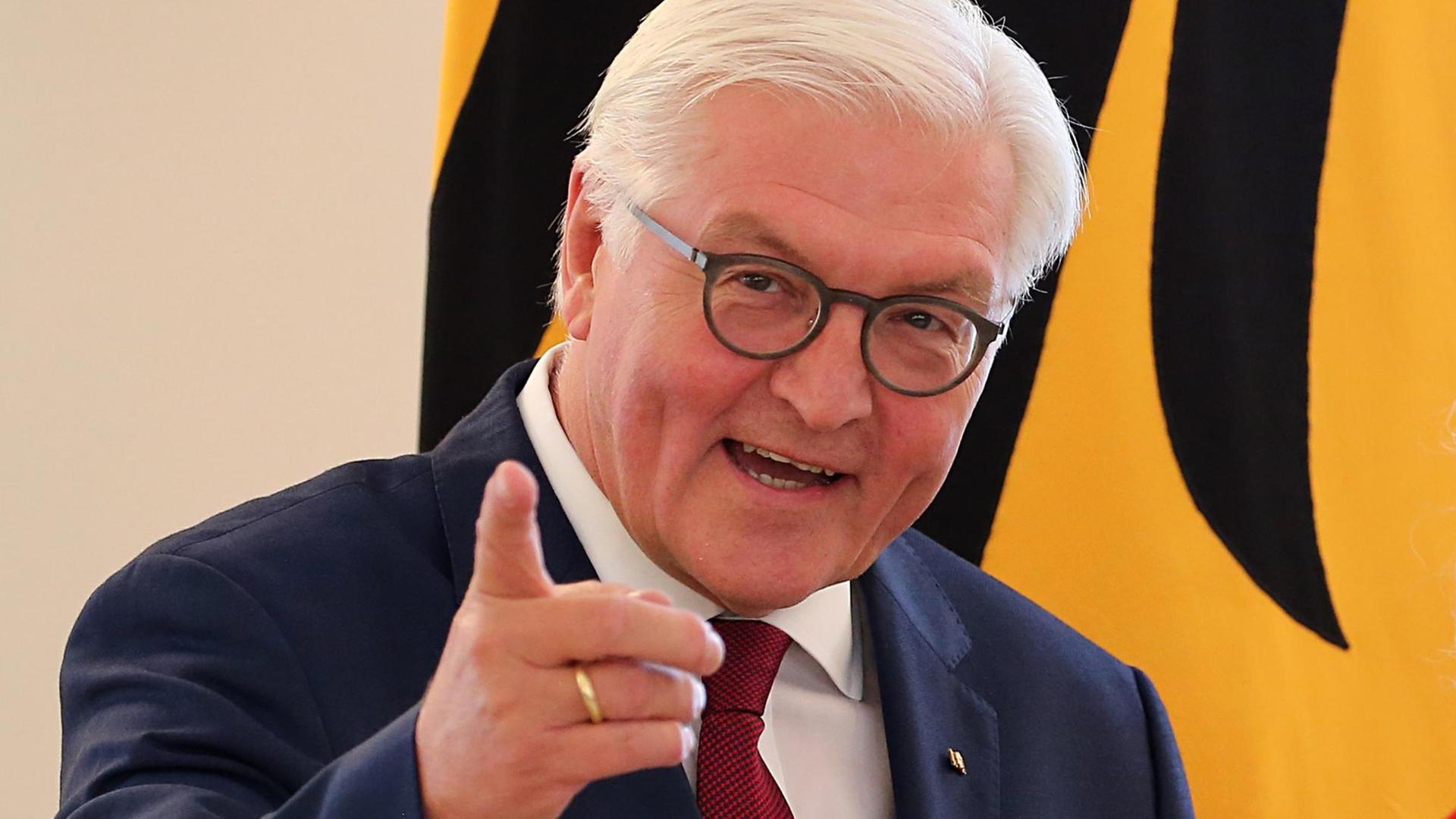 Bundespräsident Frank-Walter Steinmeier vor einer Deutschland-Flagge Bundespräsident Frank-Walter Steinmeier vor einer Deutschland-Flagge