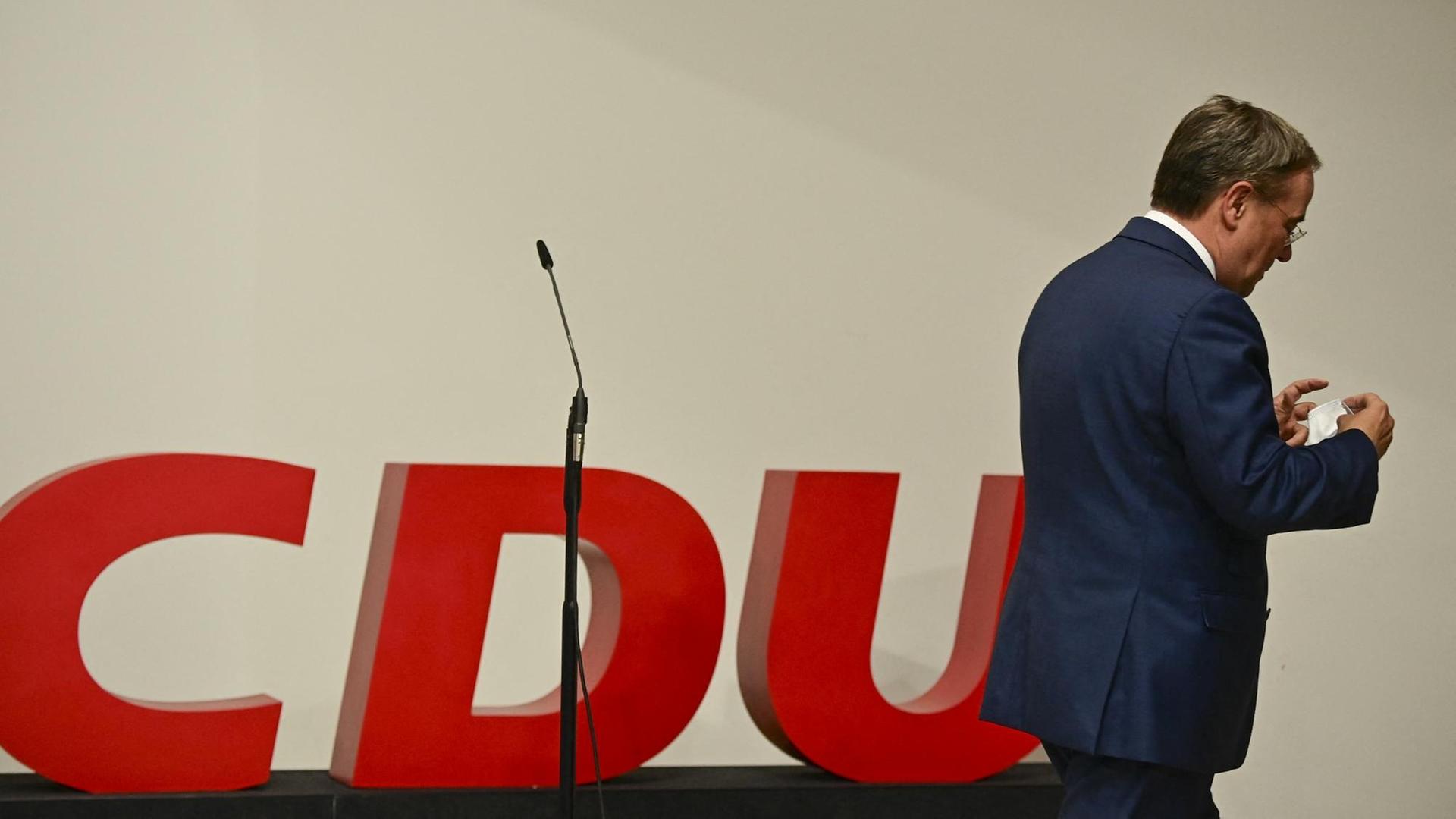 Armin Laschet verlässt eine CDU Bühne mit leerem Mikrofon. Armin Laschet verlässt eine CDU Bühne mit leerem Mikrofon.