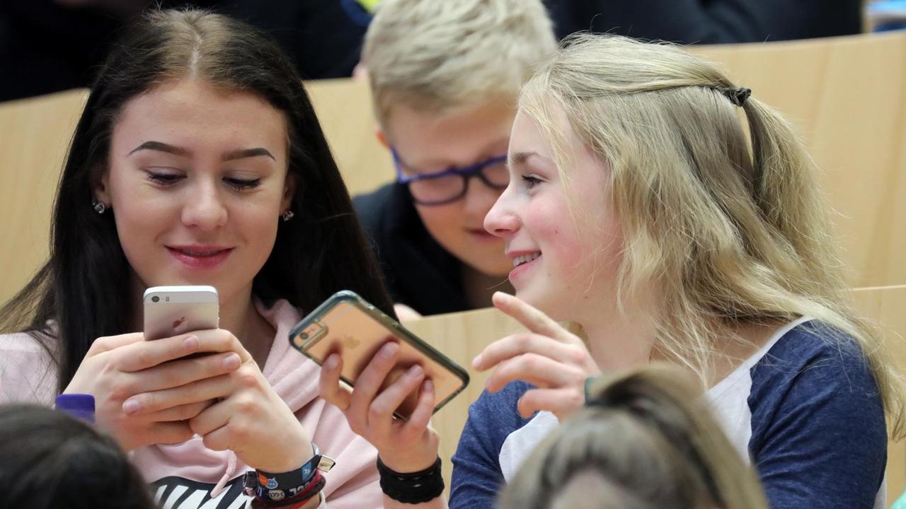 Schüler bei der Bundesjugendkonferenz Medien in Rostock tippen auf ihr Smartphone.