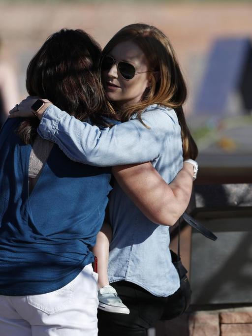 Zwei Frauen umarmen sich an der Gedenkstätte der Columbine High School in Littleton, Colorado.