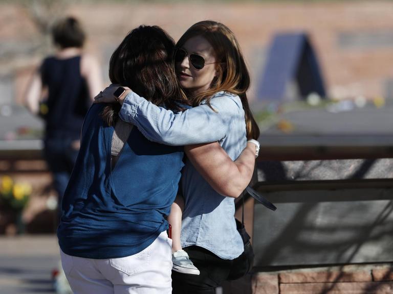 Zwei Frauen umarmen sich an der Gedenkstätte der Columbine High School in Littleton, Colorado.
