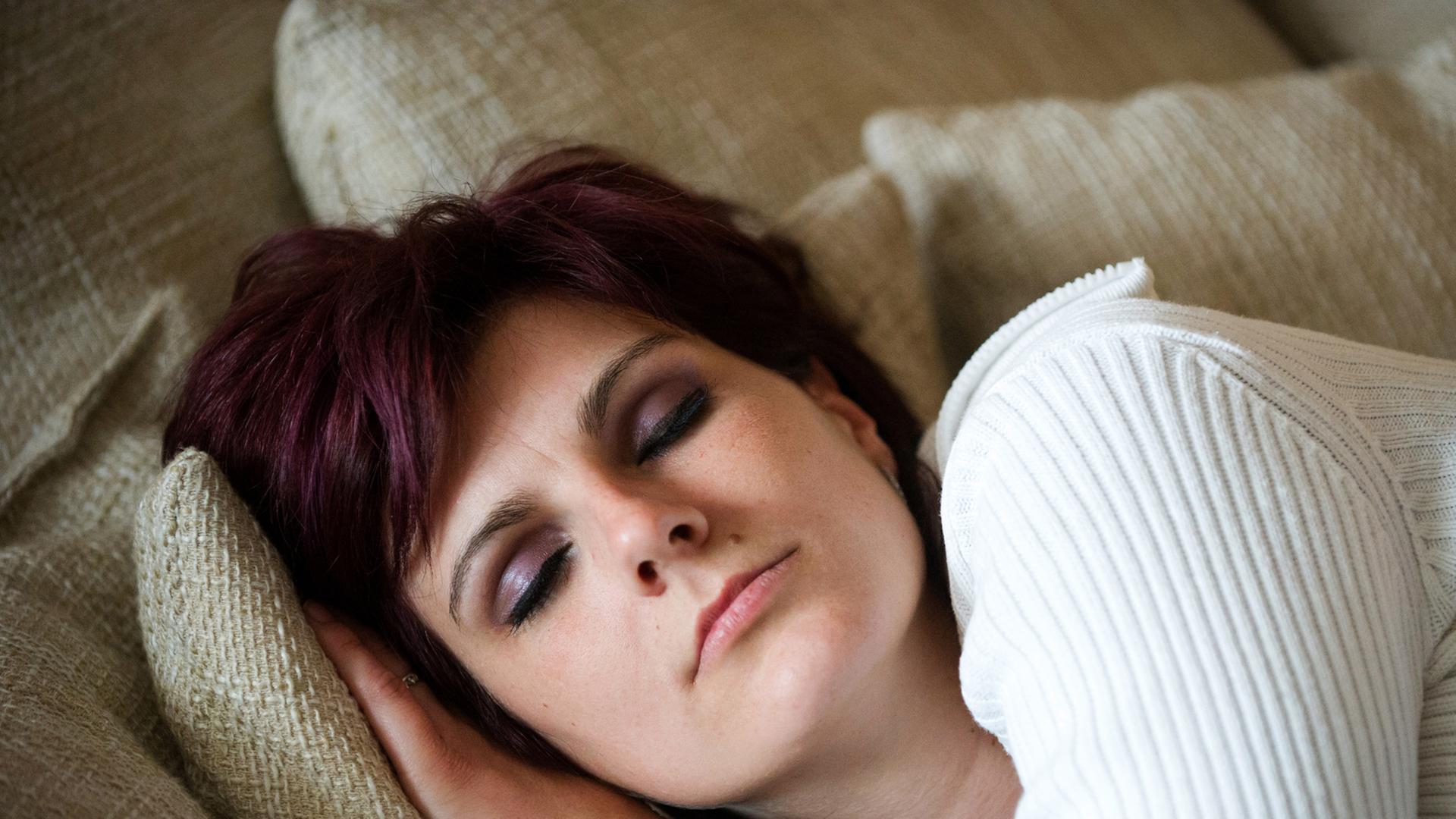 Junge Frau ruht schlafend auf dem Sofa. Junge Frau ruht schlafend auf dem Sofa.