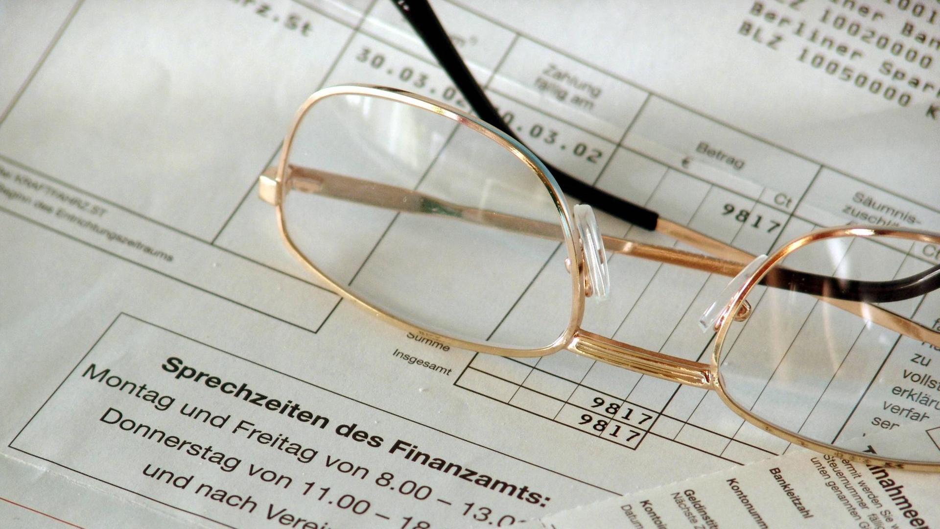Eine Lesebrille liegt auf einem Finanzamt-Bescheid Eine Lesebrille liegt auf einem Finanzamt-Bescheid