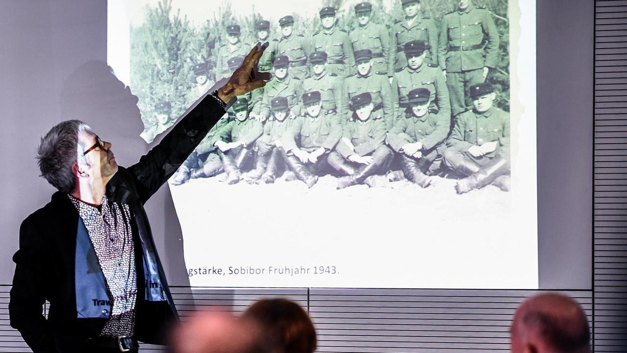 Martin Cüppers, wissenschaftlicher Leiter der Forschungsstelle Ludwigsburg der Universität Stuttgart, zeigt bei einer Pressekonferenz in der Stiftung Topographie des Terrors über eine Sammlung von Bildern aus dem Vernichtungslager Sobibor auf ein Foto, auf dem mutmaßlich der verurteilte Aufseher John Iwan Demjanjuk zu sehen ist