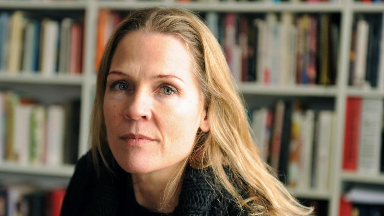 Eine Frau mit langen glatten blonden Haare von einer Bücherwand. Eine Frau mit langen glatten blonden Haare von einer Bücherwand.
