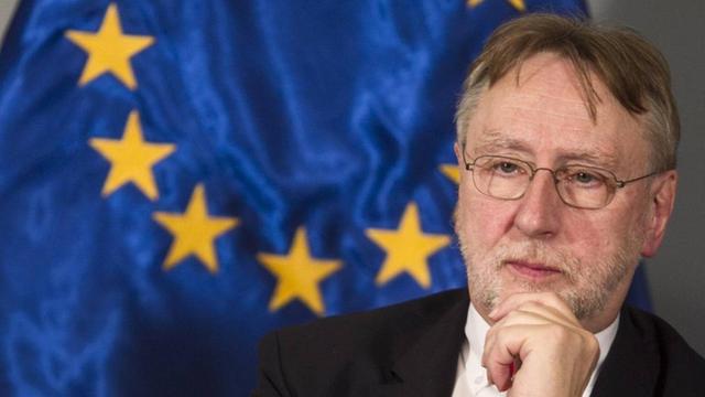 EU-Politiker Bernd Lange (SPD) sitzt vor einer EU-Flagge