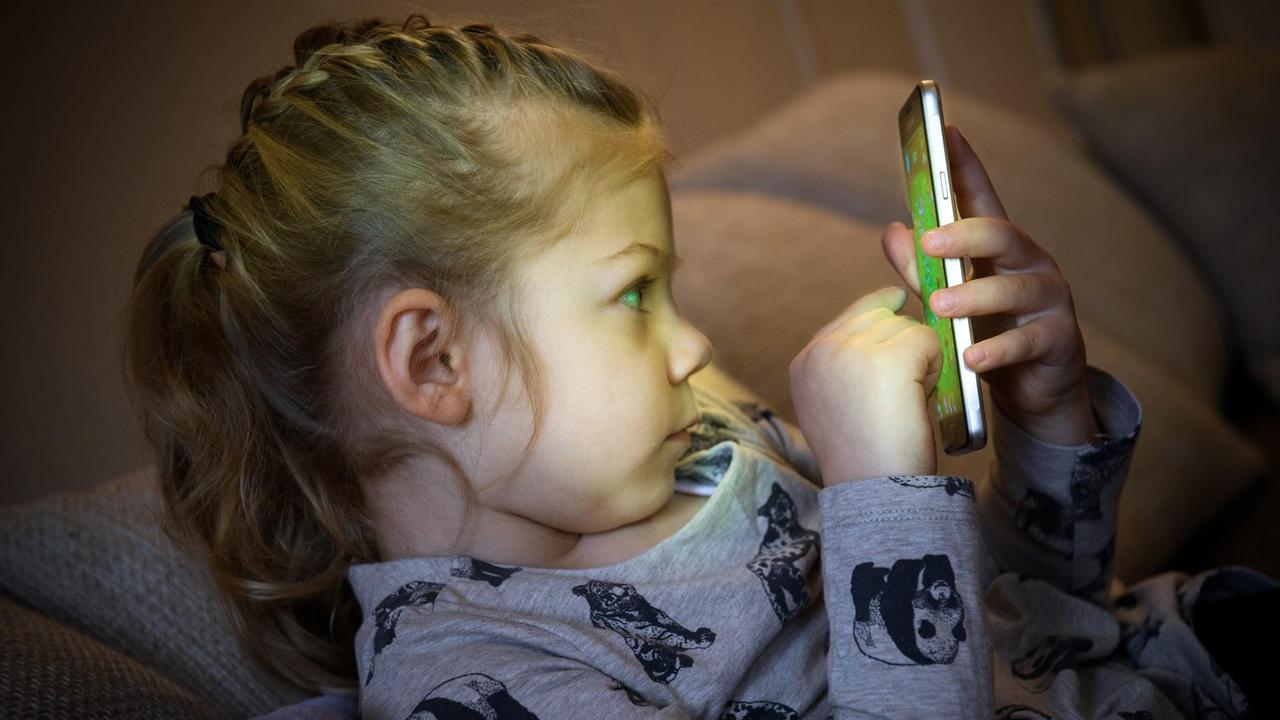 Ein kleines Mädchen spielt ein Game auf einem Smartphone, aufgenommen am 08.02.2017 in Berlin. Ein kleines Mädchen spielt ein Game auf einem Smartphone, aufgenommen am 08.02.2017 in Berlin.