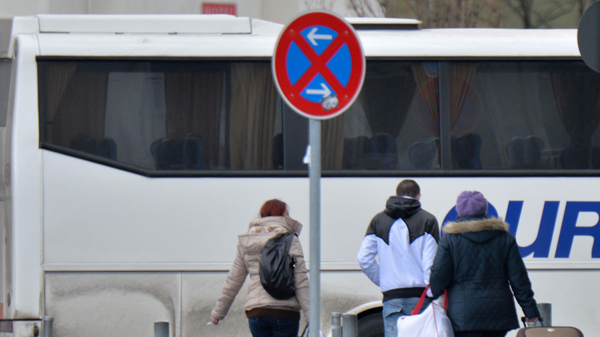 Fahrgäste eines aus Rumänien eingetroffenen Reisebusses gehen am 08.01.2014 in Berlin an einer Haltestelle des Zentralen Omnibusbahnhofes Berlin (ZOB) mit ihren Koffern zum Ausgang.