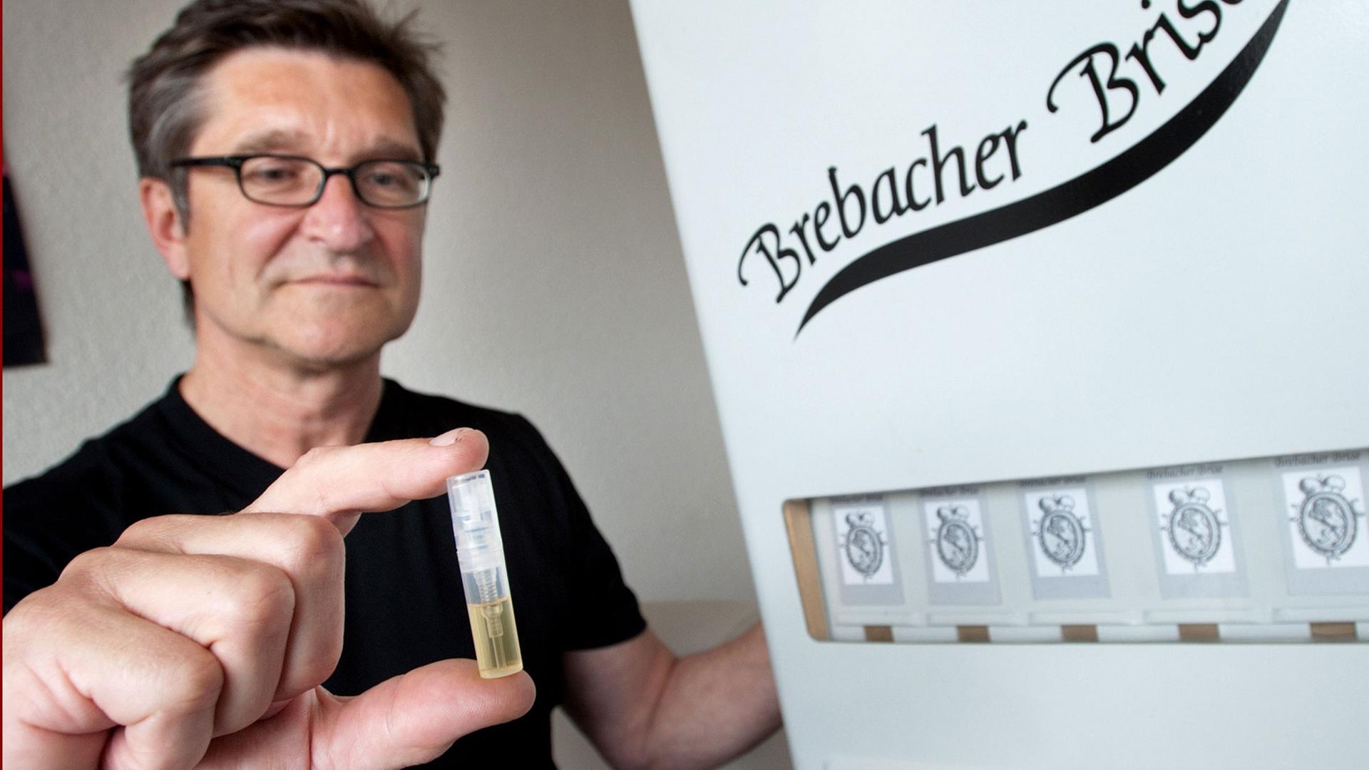 Stadtteilmanager Manfred Hahn stellt am 31.05.2010 in Saarbrücken einen Minizerstäuber mit Parfüm vor, in dem der typische Gießereigeruch des Saarbrücker Stadtteils Brebach konserviert ist. "Brebacher Brise" heißt der Duft des Düsseldorfer Parfümeurs Frank Rittler, der auch an eine heiß gelaufene Zugbremse erinnert. Die ersten Exemplare konnten für zwei Euro aus einem ehemaligen Süßigkeitenautomaten gezogen werden. Stadtteilmanager Manfred Hahn stellt am 31.05.2010 in Saarbrücken einen Minizerstäuber mit Parfüm vor, in dem der typische Gießereigeruch des Saarbrücker Stadtteils Brebach konserviert ist. "Brebacher Brise" heißt der Duft des Düsseldorfer Parfümeurs Frank Rittler, der auch an eine heiß gelaufene Zugbremse erinnert. Die ersten Exemplare konnten für zwei Euro aus einem ehemaligen Süßigkeitenautomaten gezogen werden.