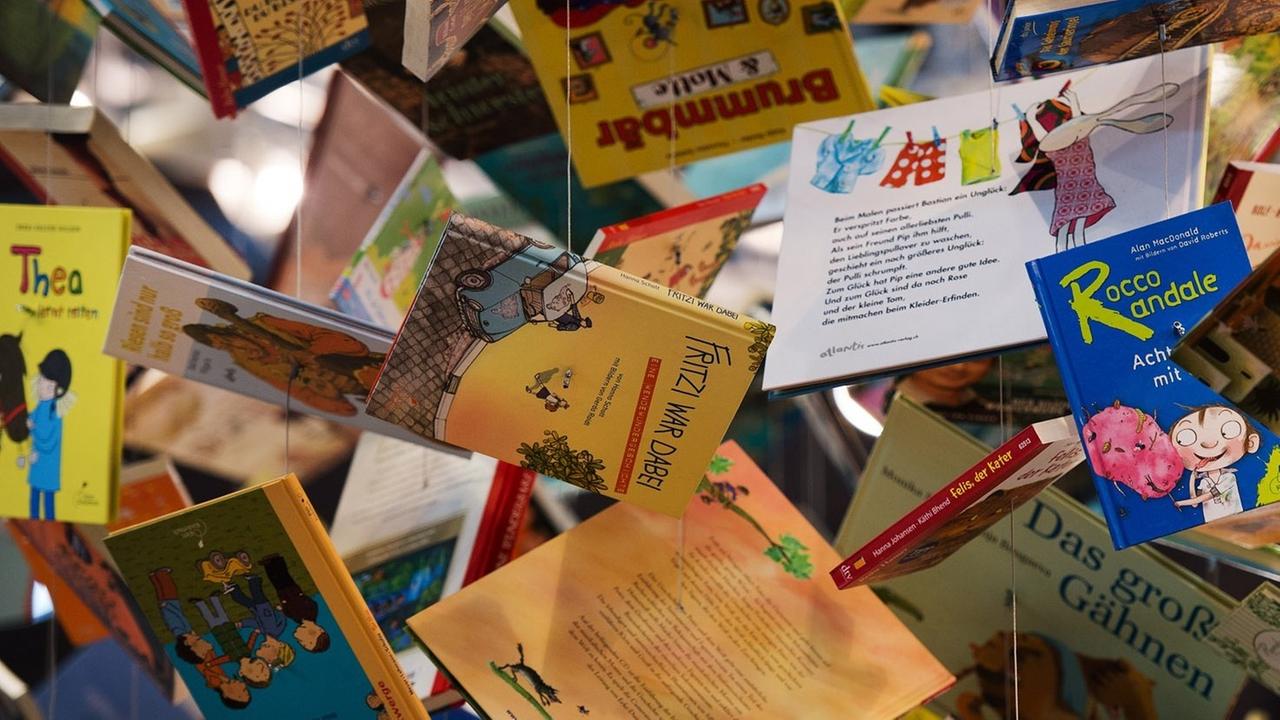 An der Decke über dem Stand der Kooperation Kinder- und Jugendbuch des Deutschen Taschenbuch Verlages (dtv) hängen am 14.03.2014 auf der Leipziger Buchmesse in Leipzig (Sachsen) Bücher an Fäden. An der Decke über dem Stand der Kooperation Kinder- und Jugendbuch des Deutschen Taschenbuch Verlages (dtv) hängen am 14.03.2014 auf der Leipziger Buchmesse in Leipzig (Sachsen) Bücher an Fäden.
