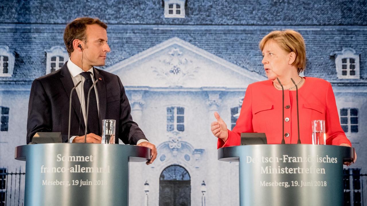 19.06.2018, Brandenburg, Meseberg: Bundeskanzlerin Angela Merkel (CDU,r) und Emmanuel Macron, Präsident von Frankreich, sprechen bei einer Pressekonferenz beim Deutsch-Französischen Ministerrat auf Schloss Meseberg. 19.06.2018, Brandenburg, Meseberg: Bundeskanzlerin Angela Merkel (CDU,r) und Emmanuel Macron, Präsident von Frankreich, sprechen bei einer Pressekonferenz beim Deutsch-Französischen Ministerrat auf Schloss Meseberg.