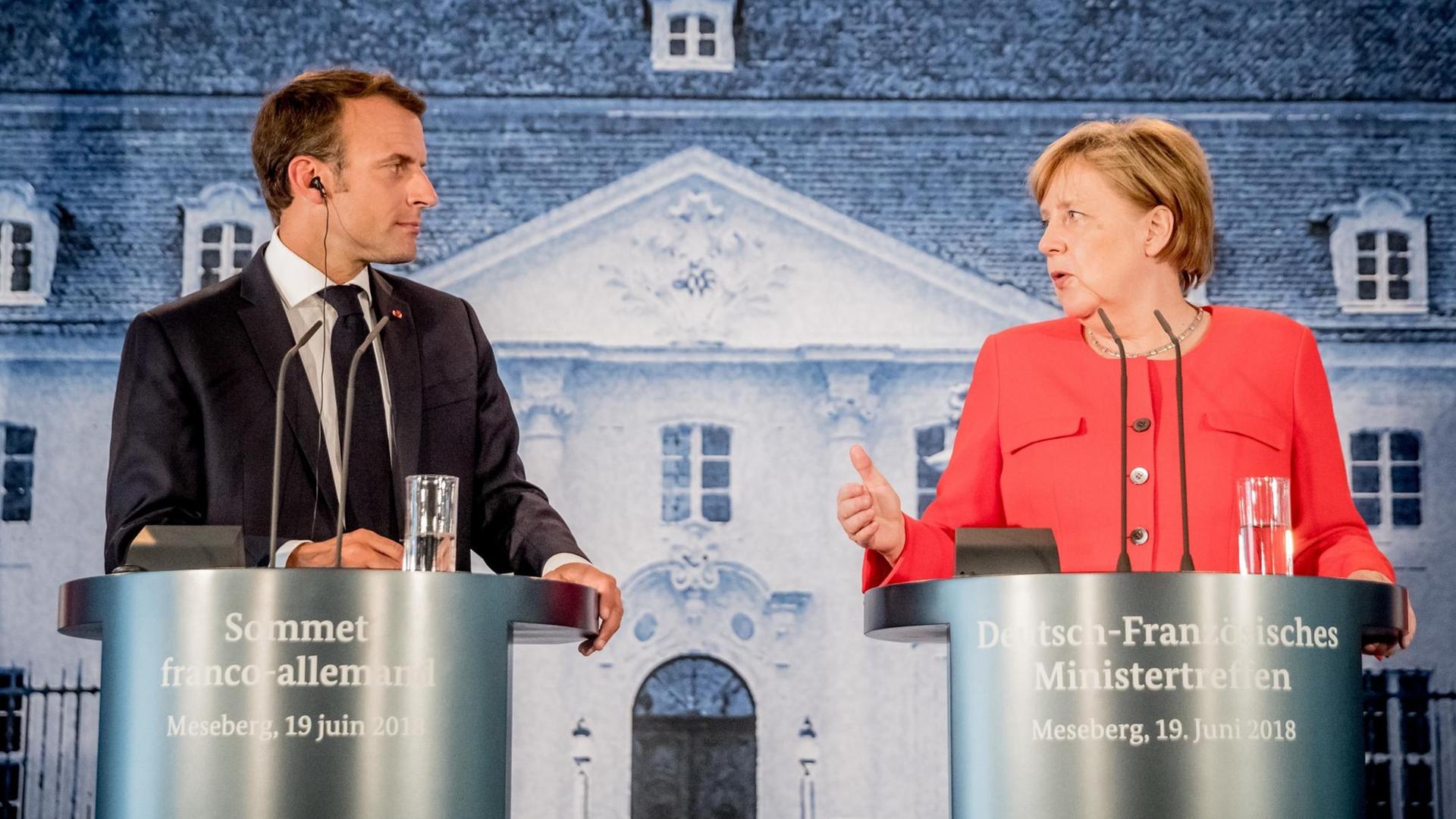 19.06.2018, Brandenburg, Meseberg: Bundeskanzlerin Angela Merkel (CDU,r) und Emmanuel Macron, Präsident von Frankreich, sprechen bei einer Pressekonferenz beim Deutsch-Französischen Ministerrat auf Schloss Meseberg. 19.06.2018, Brandenburg, Meseberg: Bundeskanzlerin Angela Merkel (CDU,r) und Emmanuel Macron, Präsident von Frankreich, sprechen bei einer Pressekonferenz beim Deutsch-Französischen Ministerrat auf Schloss Meseberg.