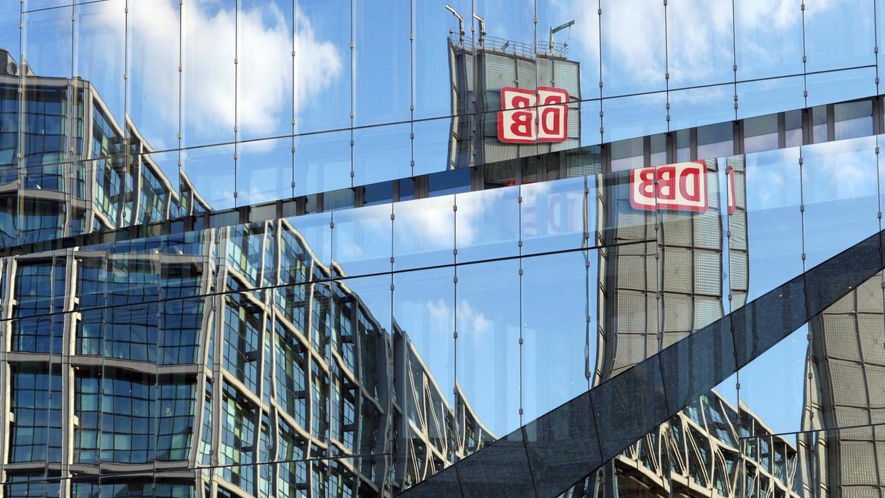 Das Logo der Deutschen Bahn in einer Verzerrung auf einer Spiegelfassade.