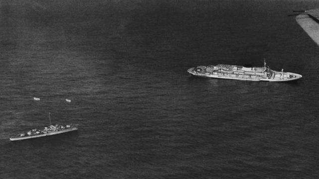 Ein Schiff der amerikanischen Marine nimmt Kurs auf ein paar im Meer treibende Rettungsboote des Luxus-Liners "Andrea Doria".