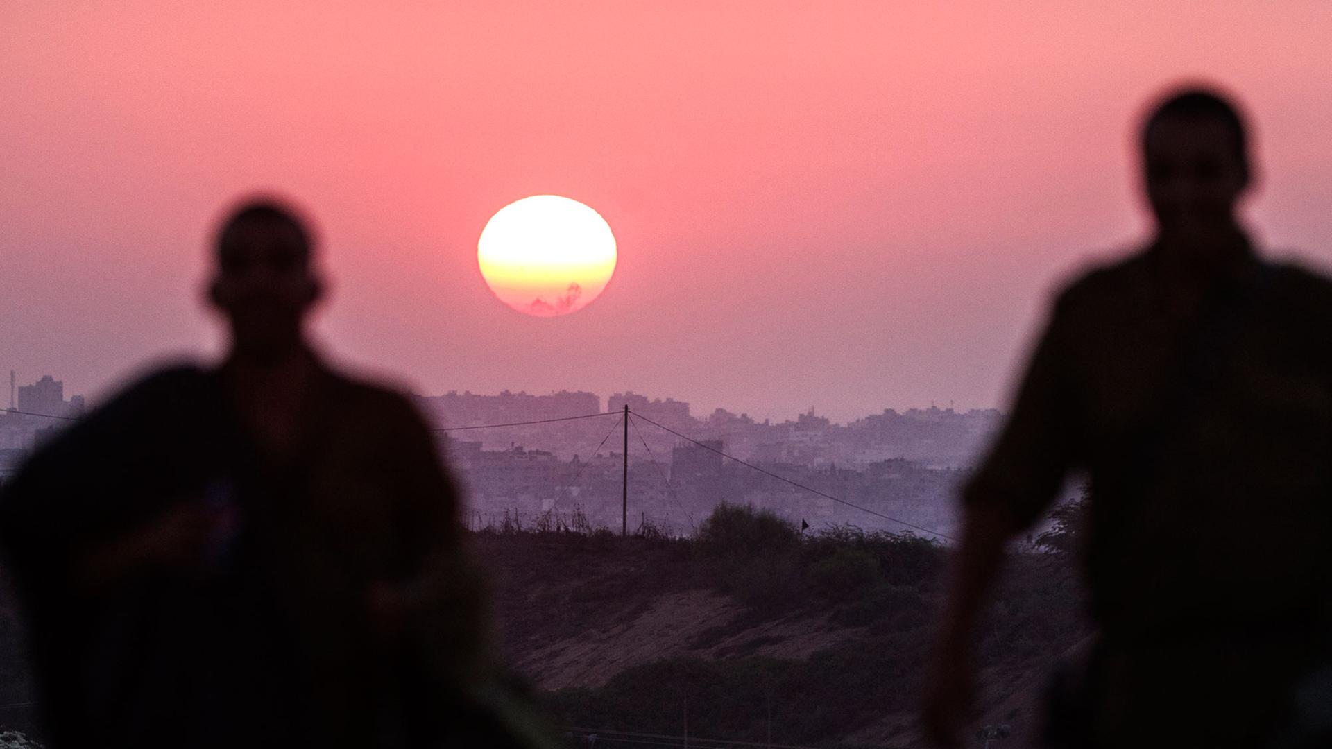 Zwei Soldaten betrachten den Sonnenuntergang über dem Gazastreifen am 4. August 2014. Zwei Soldaten betrachten den Sonnenuntergang über dem Gazastreifen am 4. August 2014.
