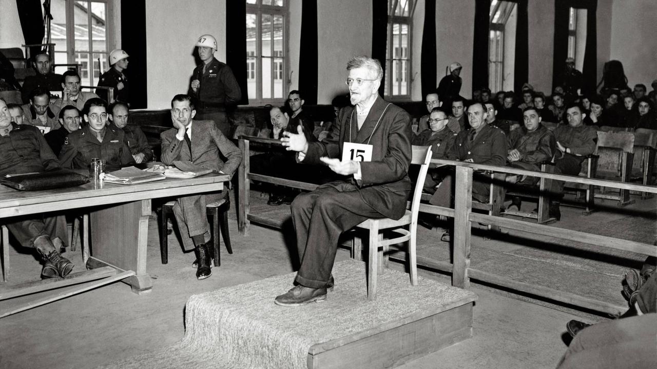 Dachauer Kriegsverbrecherprozess: Der Angeklagte Dr. Claus Schilling (Lagerarzt, der Malariaexperimente durchgeführt hat) sitzt auf dem Angeklagten-Stuhl vor einem U.S.-Militärgericht, im Saal Zuschauer und Wachpersonal. Schilling wurde am 13.12.1945 zum Tode verurteilt und am 29.05.1946 gehängt. Dachauer Kriegsverbrecherprozess: Der Angeklagte Dr. Claus Schilling (Lagerarzt, der Malariaexperimente durchgeführt hat) sitzt auf dem Angeklagten-Stuhl vor einem U.S.-Militärgericht, im Saal Zuschauer und Wachpersonal. Schilling wurde am 13.12.1945 zum Tode verurteilt und am 29.05.1946 gehängt.