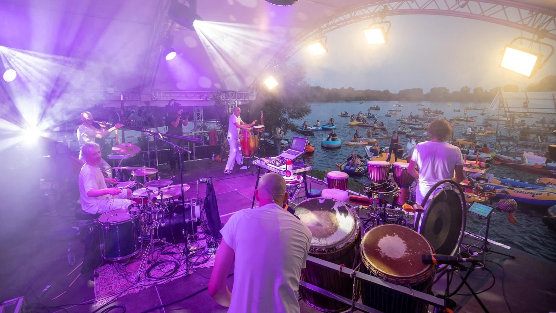 Die Band Orange spielt ein Konzert auf der Seebühne am Großen Dutzendteich vor Zuschauern, die auf ihren eigenen Booten das Konzert verfolgen Die Band Orange spielt ein Konzert auf der Seebühne am Großen Dutzendteich vor Zuschauern, die auf ihren eigenen Booten das Konzert verfolgen