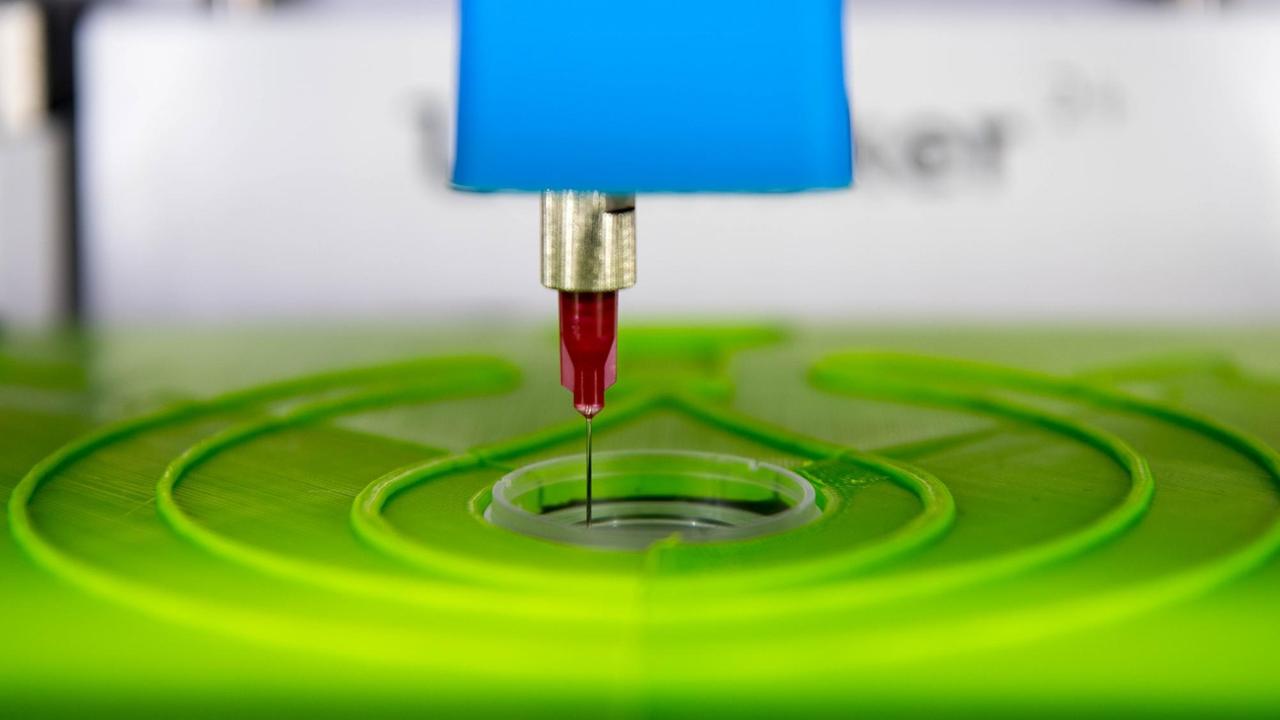 Der biotINK-Gewebedrucker druckt mit einer Kanüle Gewebe in eine kleine Petrischale Der biotINK-Gewebedrucker druckt mit einer Kanüle Gewebe in eine kleine Petrischale