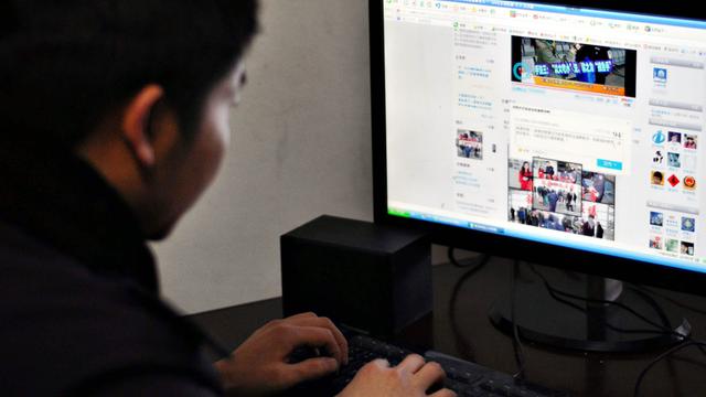 Ein Chinese sitzt vor einem Computer und nutzt den Twitter-ähnlichen Mikroblogdienst Weibo.
