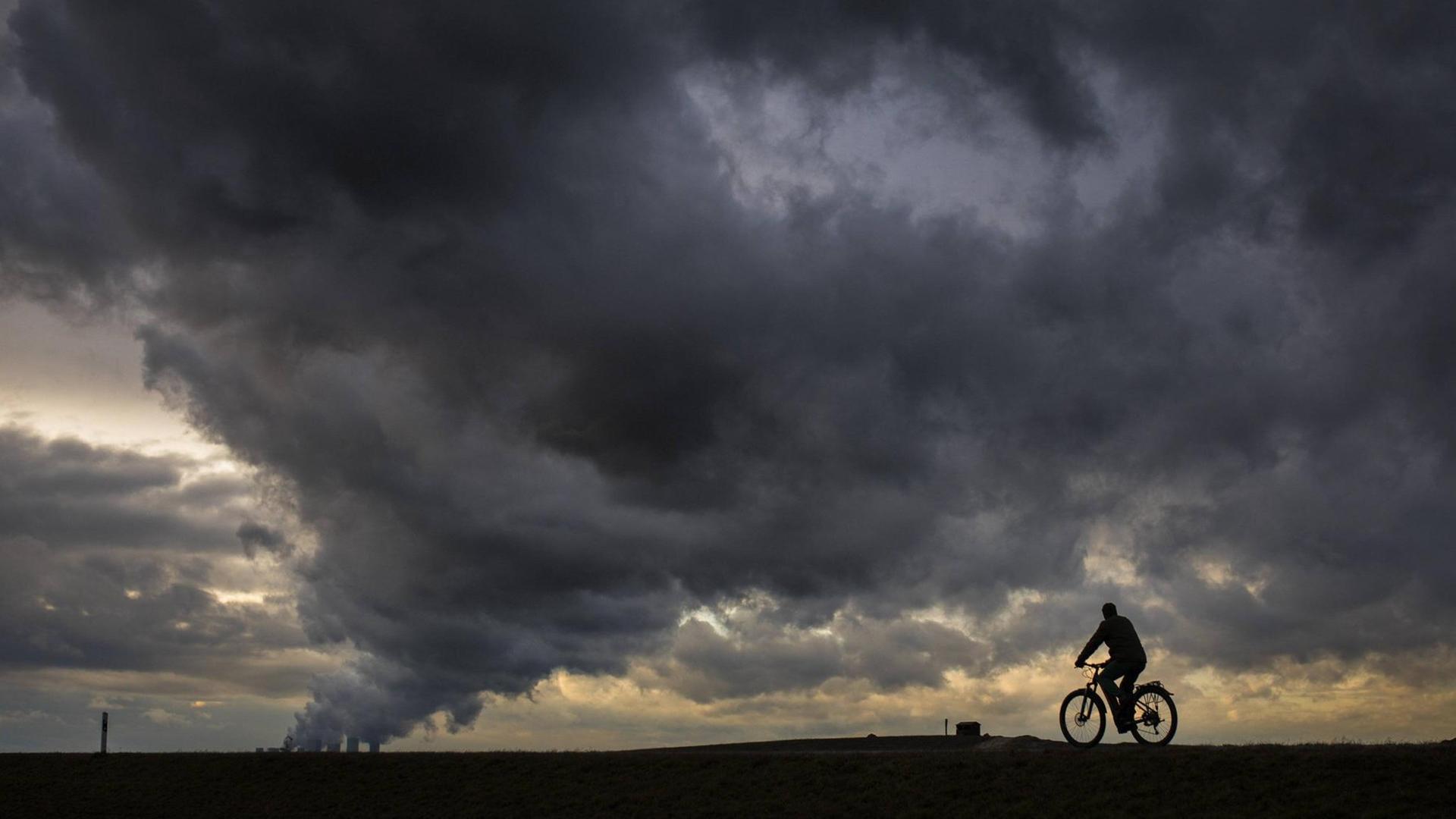 Ein Radfahrer zeichnet sich vor dem Braunkohlekraftwerk Boxberg ab, aufgenommen in Altliebel am 11.03.2019 Ein Radfahrer zeichnet sich vor dem Braunkohlekraftwerk Boxberg ab, aufgenommen in Altliebel am 11.03.2019