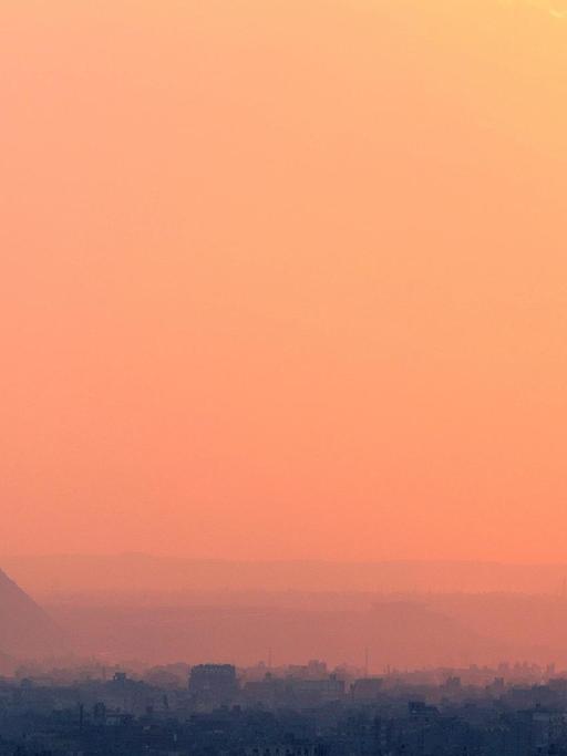 Sonnenuntergan vor dem Hintergrund der Pyramiden von Gizeh und Kairos im Dezember 2018.