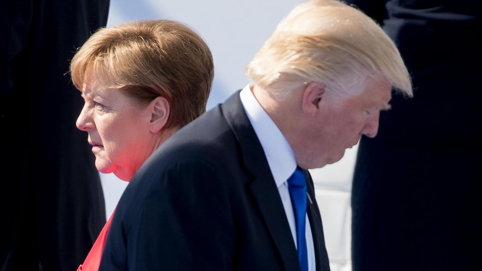 ARCHIV - Der Präsident der Vereinigten Staaten von Amerika, Donald Trump, und Bundeskanzlerin Angela Merkel (CDU) gehen am 25.05.2017 in Brüssel beim Nato-Gipfel bei der feierlichen Eröffnung des neuen Nato-Hauptquartiers an einander vorbei.