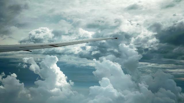 Dramatische Wolkenbildung und Tragfläche Boing 777-300