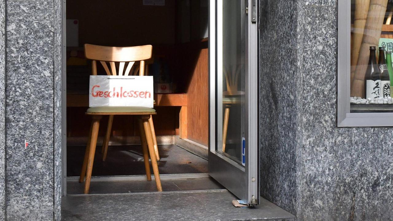 Stuhl mit Geschlossen-Schild in Tür von Frankfurter Lokal Stuhl mit Geschlossen-Schild in Tür von Frankfurter Lokal
