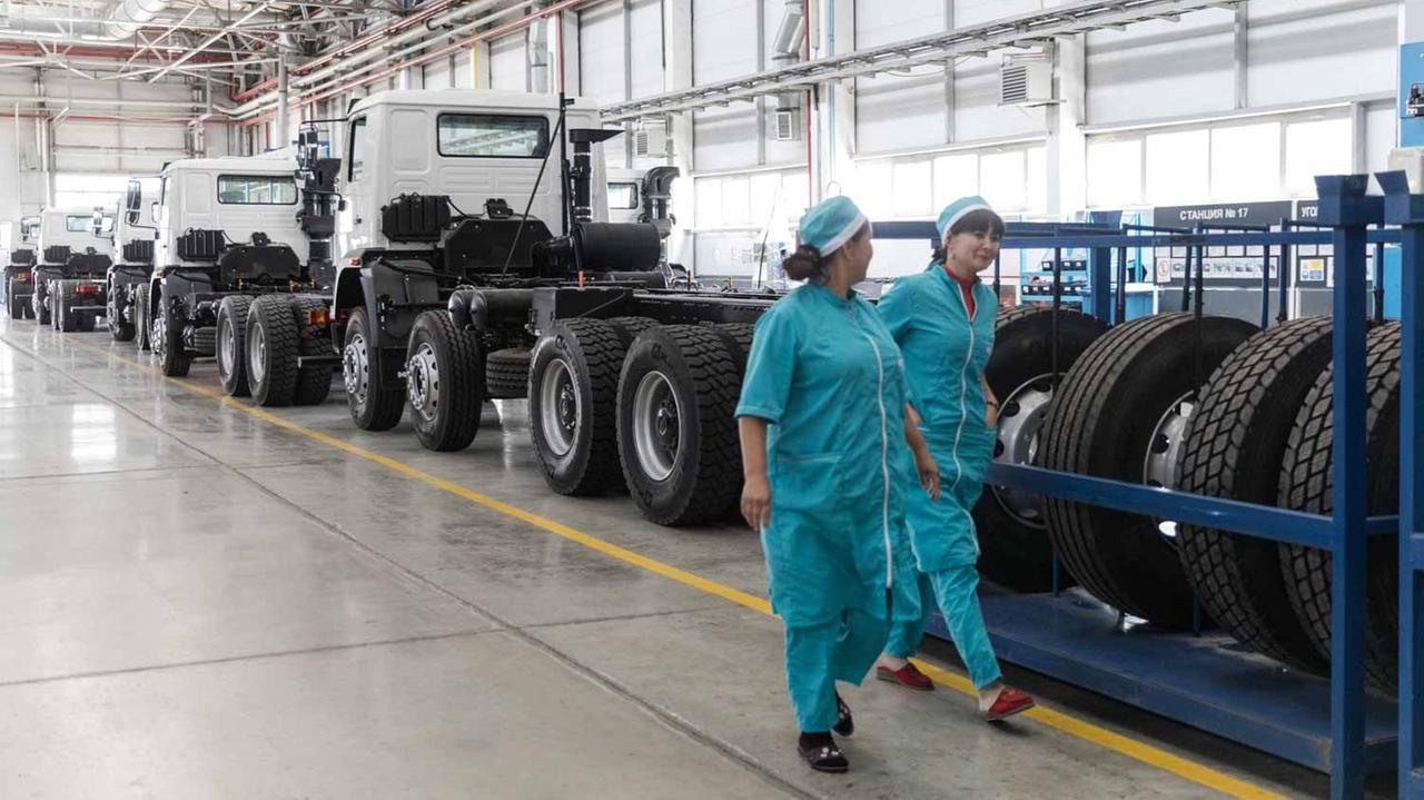 Mitarbeiterinnen vor einer Reihe von Lastwagen in einer Halle der Firma MAN in Samarkand, Usbekistan Mitarbeiterinnen vor einer Reihe von Lastwagen in einer Halle der Firma MAN in Samarkand, Usbekistan