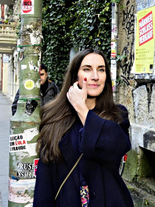 Mirna Funk steht auf einer Straße in Berlin.