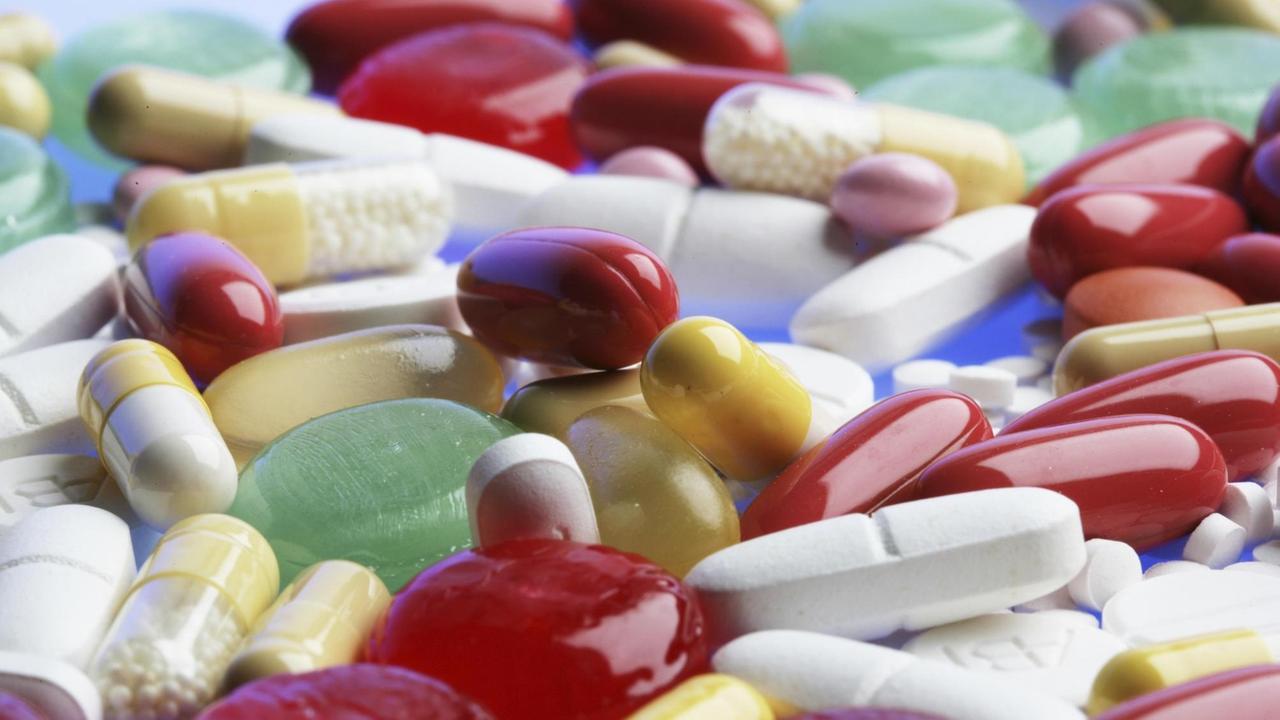 Eine Fülle von unterschiedlichen, bunten Tabletten und Pillen liegt auf einem Haufen.
