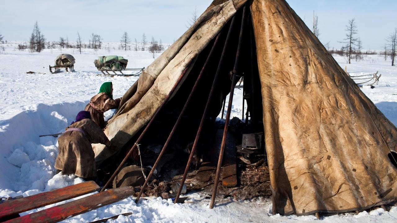 Zwei Menschen vom indigenen Volk der Nenzen bauen eins ihrer Zelte auf, deren Form und Struktur sich in 3000 Jahren nicht verändert haben.