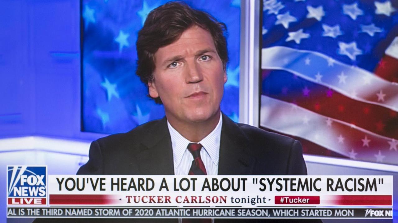 Tucker Carlson in seiner TV-Show, in einem Spruchband steht "Sie haben viel über 'systematischen Rassismus' gehört." Tucker Carlson in seiner TV-Show, in einem Spruchband steht "Sie haben viel über 'systematischen Rassismus' gehört."