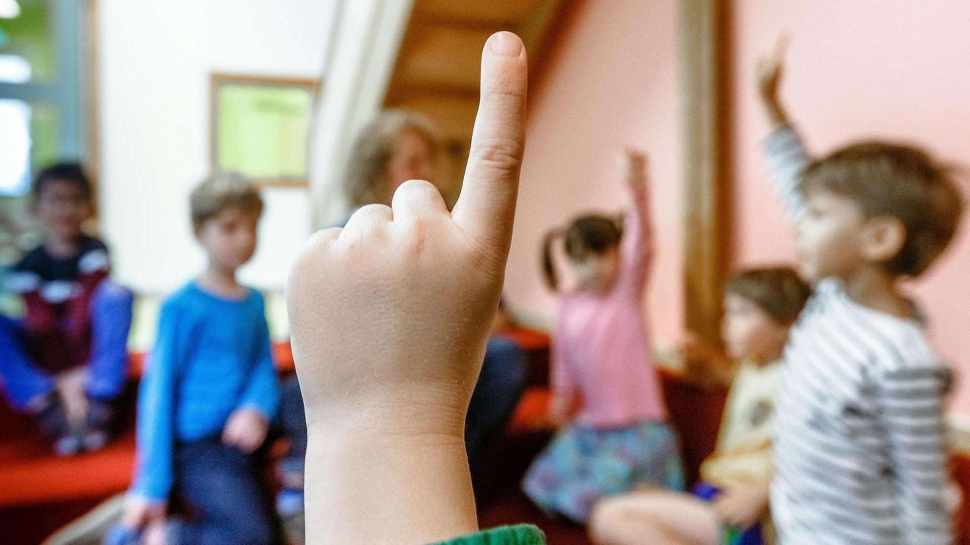 Mehrere Kita-Kinder heben bei einer Abstimmung die Hand Mehrere Kita-Kinder heben bei einer Abstimmung die Hand