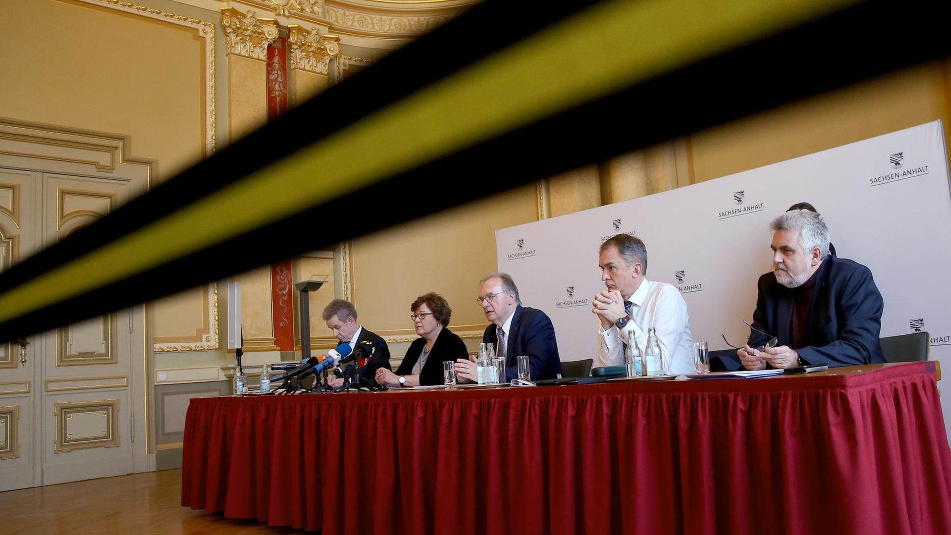 Teile von Sachsen-Anhalts Landesregierung bei einer Pressekonferenz, wegen der Coronakrise hinter einem Absperrband Teile von Sachsen-Anhalts Landesregierung bei einer Pressekonferenz, wegen der Coronakrise hinter einem Absperrband