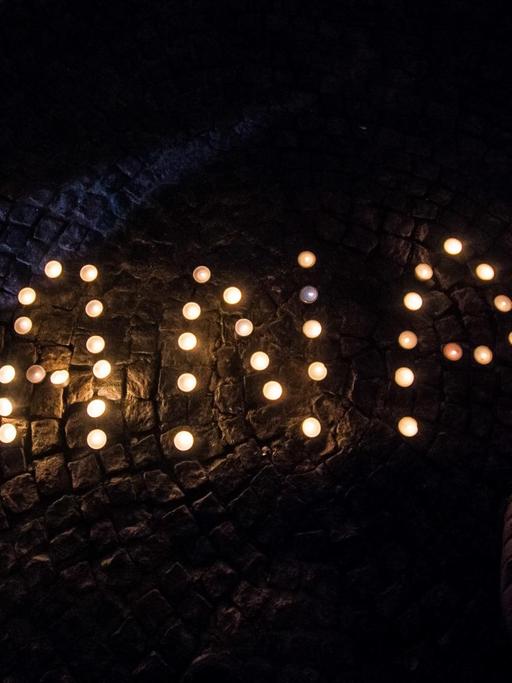 In München haben Menschen bei einer Gedenkveranstaltung mit Kerzen das Wort "Hanau" gebildet