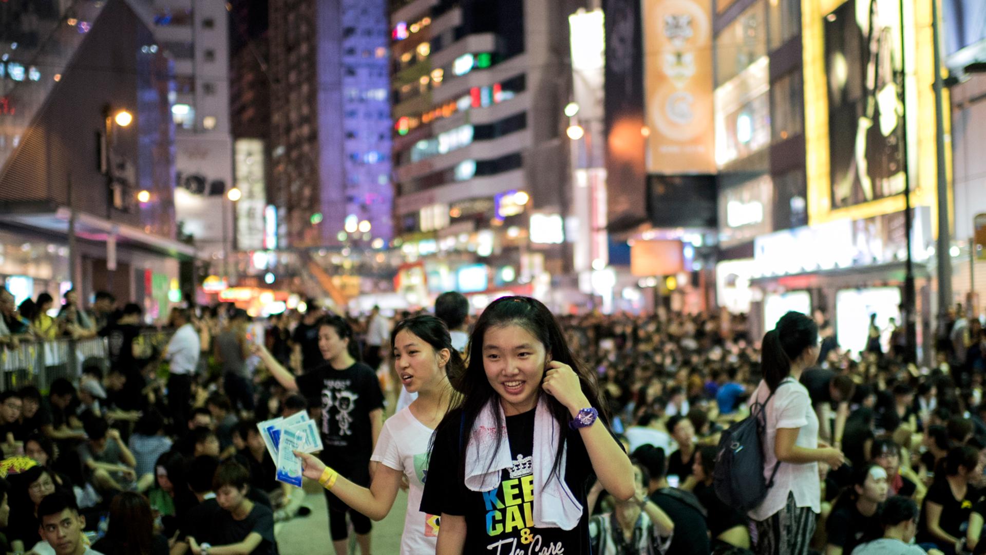 Zwei junge Frauen verteilen Essen an Pro-Demokratie-Demonstranten in Hongkong Zwei junge Frauen verteilen Essen an Pro-Demokratie-Demonstranten in Hongkong