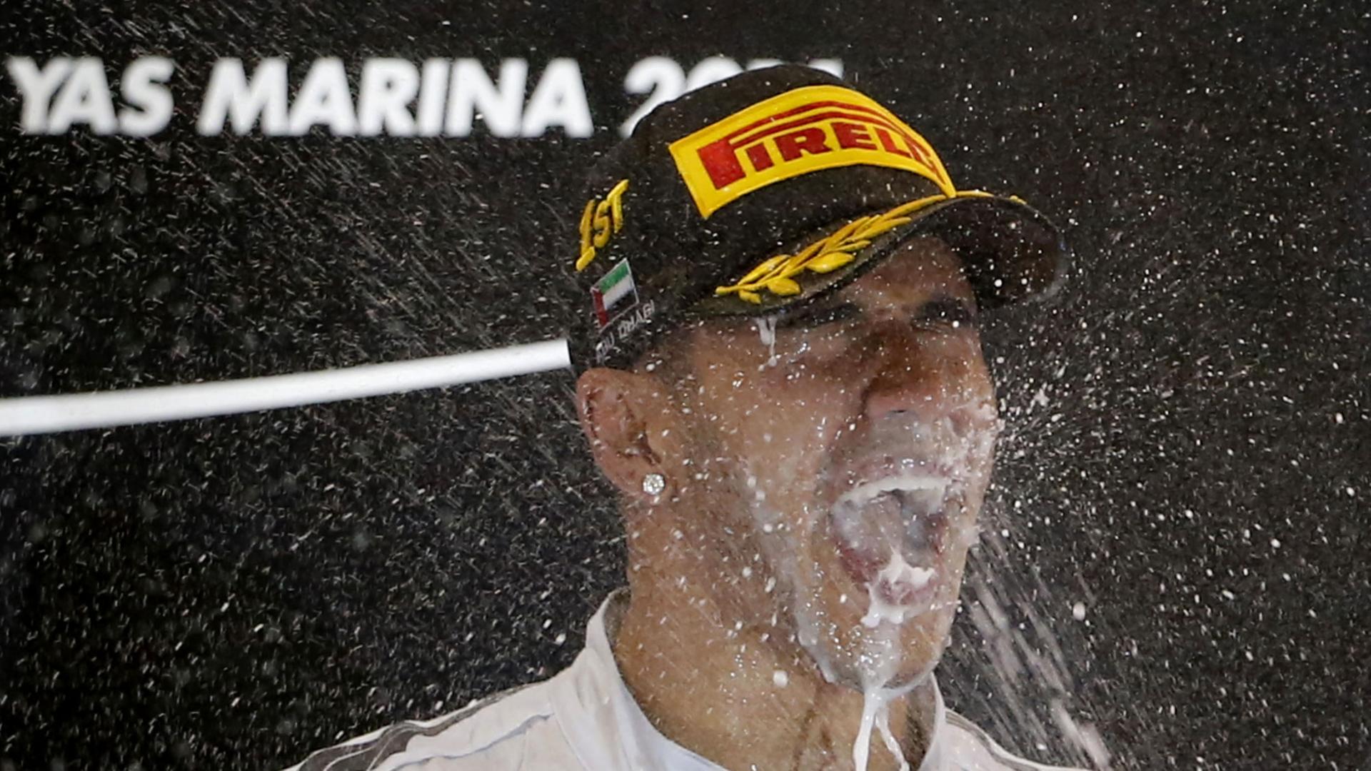 Mercedes-AMG-Fahrer Lewis Hamilton feiert seinen Formel-1-Weltmeistertitel auf dem Podium an der Rennstrecke in Abu Dhabi.