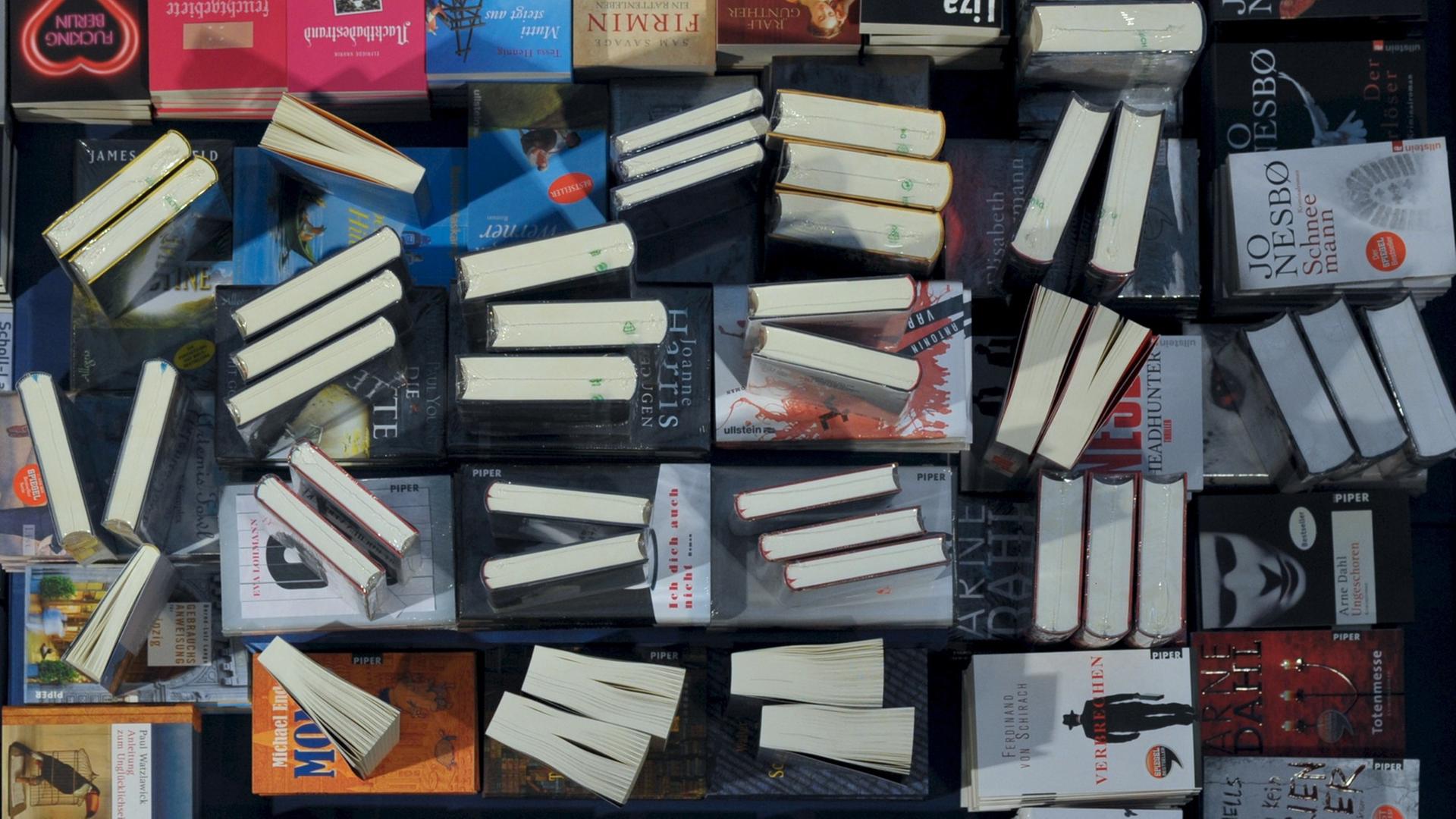 Eine Hand greift nach einem Buch auf einem Büchertisch in Leipzig. Eine Hand greift nach einem Buch auf einem Büchertisch in Leipzig.