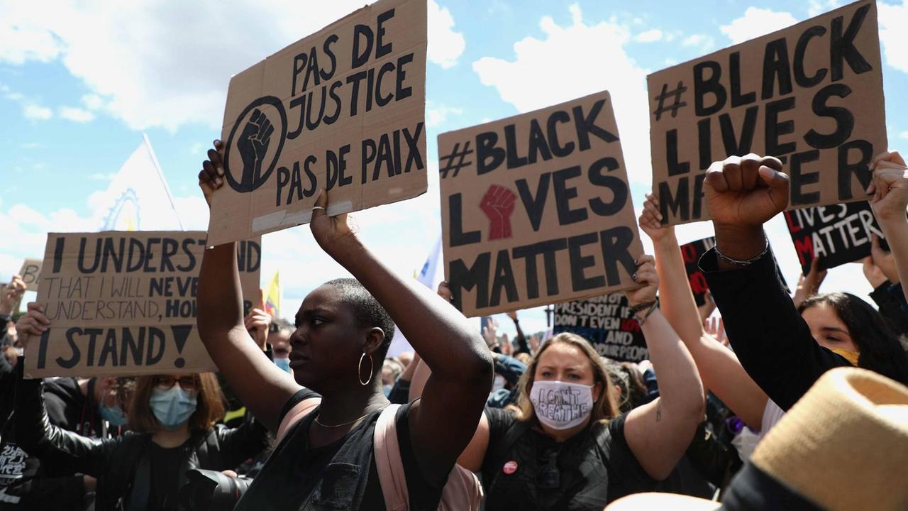 Demonstranten in Paris halten Plakate hoch. Darauf geschrieben steht "Black lives Matter" oder "Pas de Justice, pas de Paix" Demonstranten in Paris halten Plakate hoch. Darauf geschrieben steht "Black lives Matter" oder "Pas de Justice, pas de Paix"