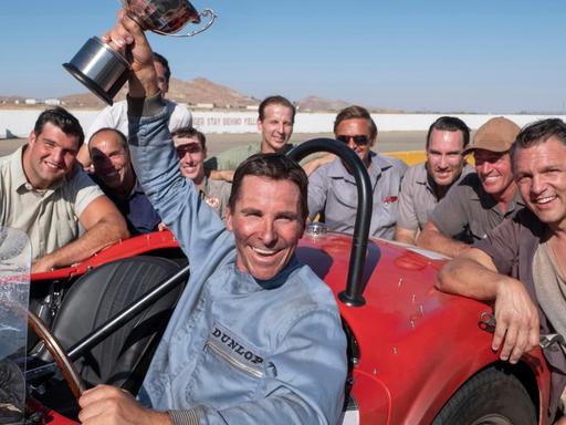 Ken Miles (Christian Bale) mit Siegerpokal in einer Szene des Films "Le Mans 66 - Gegen jede Chance" (Originaltitel: "Ford versus Ferrari").