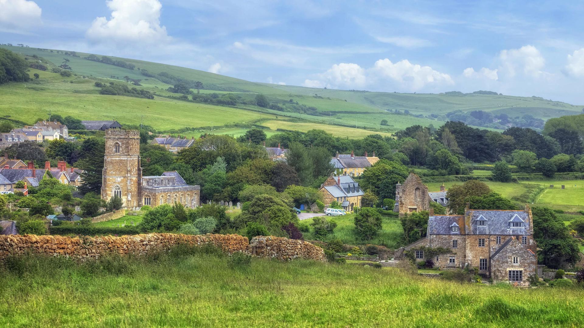 Blick auf das Dorf Abbotsbury mit der Pfarrkirche St. Nicholas in Dorset im ländlichen England Blick auf das Dorf Abbotsbury mit der Pfarrkirche St. Nicholas in Dorset im ländlichen England