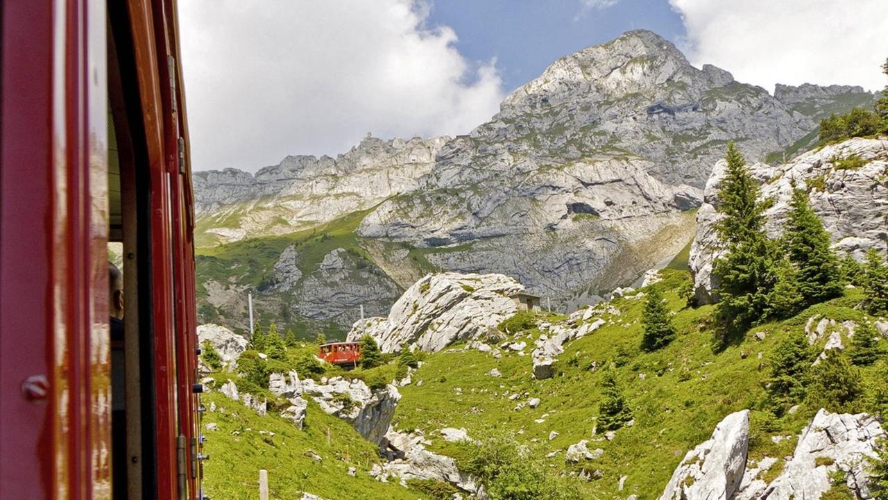 Ein Blick aus einem fahrenden Schweizer Zug auf die Berge bei Luzern Ein Blick aus einem fahrenden Schweizer Zug auf die Berge bei Luzern