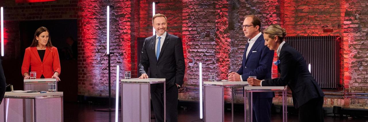 Die Kandidatinnen und Kandidaten stehen an Steh-Pulten im Fernseh-Studio Die Kandidatinnen und Kandidaten stehen an Steh-Pulten im Fernseh-Studio