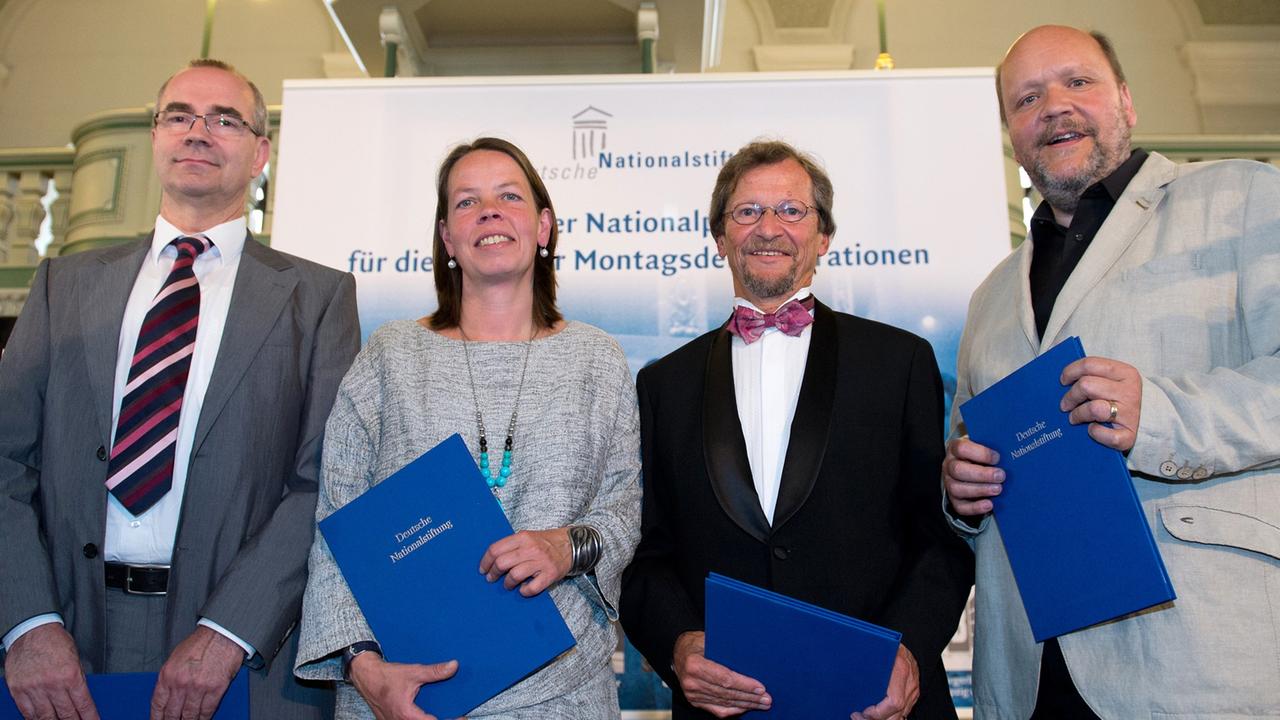 Die Preisträger Jochen Läßig (l-r), Katharina Köhler (für ihren Vater, Pfarrer Christian Führer), Pfarrer Christoph Wonneberger und Bürgerrechtler Uwe Schwabe posieren am 24.06.2014 in Berlin bei der Preisverleihung des Deutschen Nationalpreises für ein Gruppenfoto. Zum 25. Jahrestag des Mauerfalls würdigt der Deutsche Nationalpreis drei wichtige Akteure der Leipziger Montagsdemonstrationen 1989. Die Preisträger Jochen Läßig (l-r), Katharina Köhler (für ihren Vater, Pfarrer Christian Führer), Pfarrer Christoph Wonneberger und Bürgerrechtler Uwe Schwabe posieren am 24.06.2014 in Berlin bei der Preisverleihung des Deutschen Nationalpreises für ein Gruppenfoto. Zum 25. Jahrestag des Mauerfalls würdigt der Deutsche Nationalpreis drei wichtige Akteure der Leipziger Montagsdemonstrationen 1989.