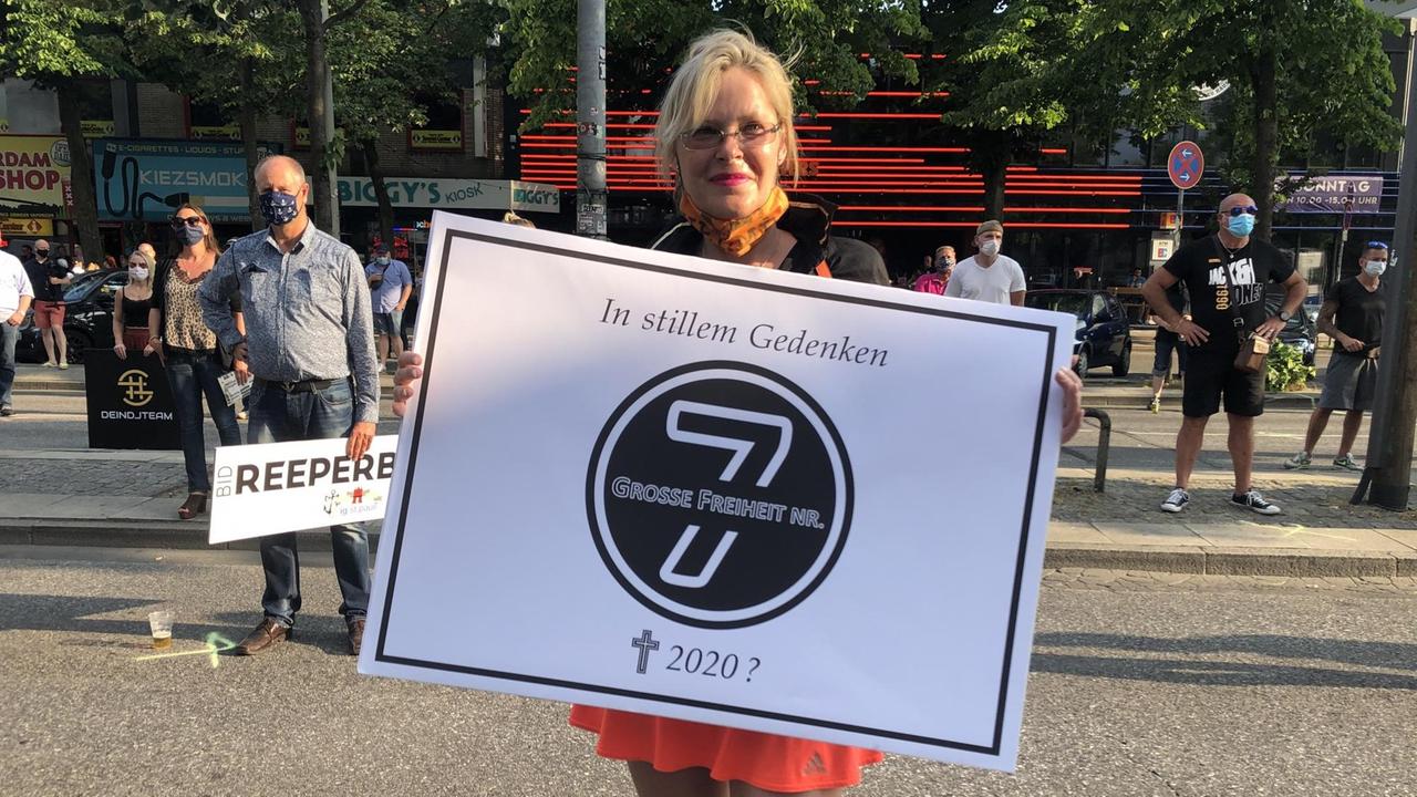 Eine protestierende Frau hält ein Schild. Eine protestierende Frau hält ein Schild.