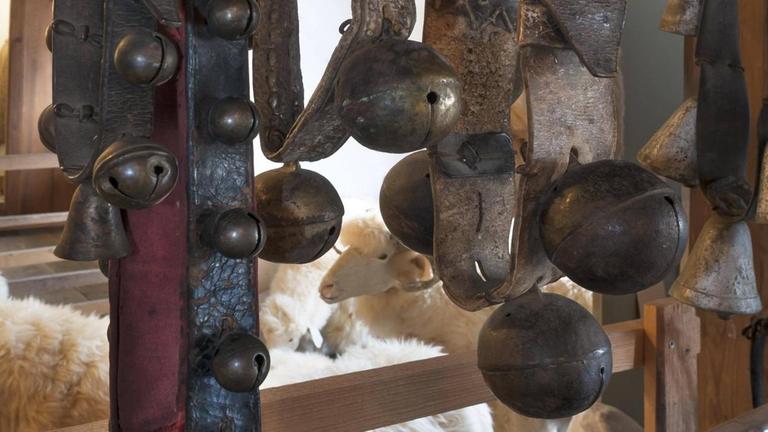 Auf einem Holzbock sind Schellengürtel aufgehangen mit unterschiedlich großen Schellen. Auf einem Holzbock sind Schellengürtel aufgehangen mit unterschiedlich großen Schellen.