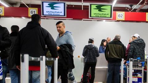 Reisende und Flüchtlinge an Check-In-Schaltern in Berlin-Tegel