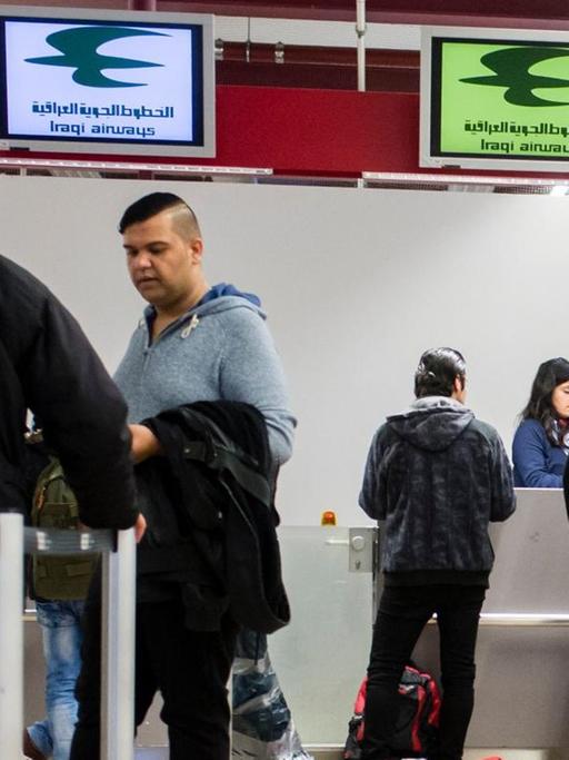 Reisende und Flüchtlinge an Check-In-Schaltern in Berlin-Tegel eines Fluges der Iraqi Airways nach Erbil.